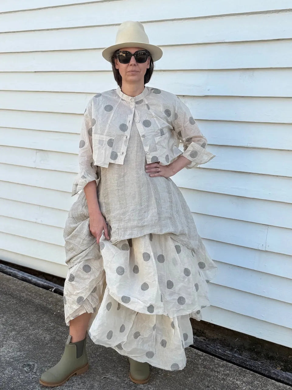 Person wearing Dogstar Tunic a layered outfit with a polka dot pattern against a white wall.