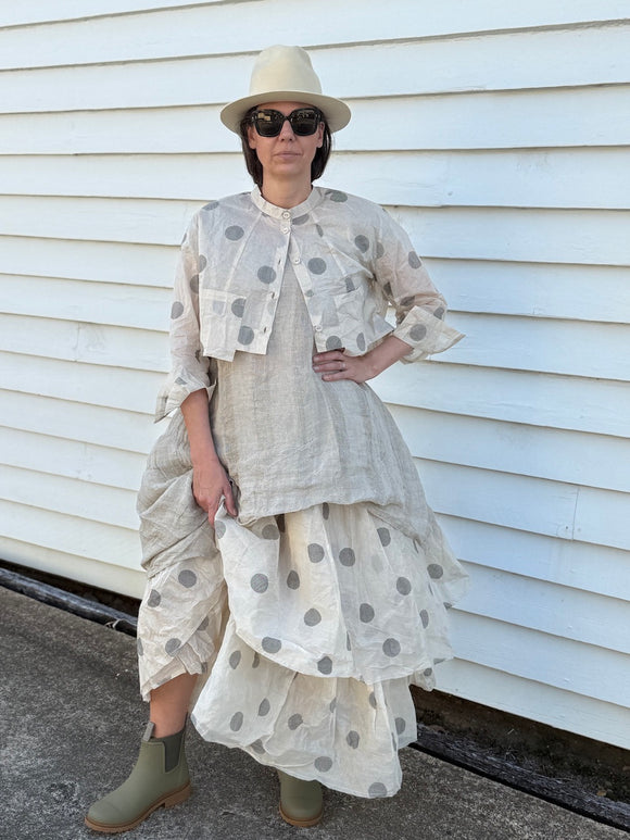 Person wearing Dogstar Tunic a layered outfit with a polka dot pattern against a white wall.