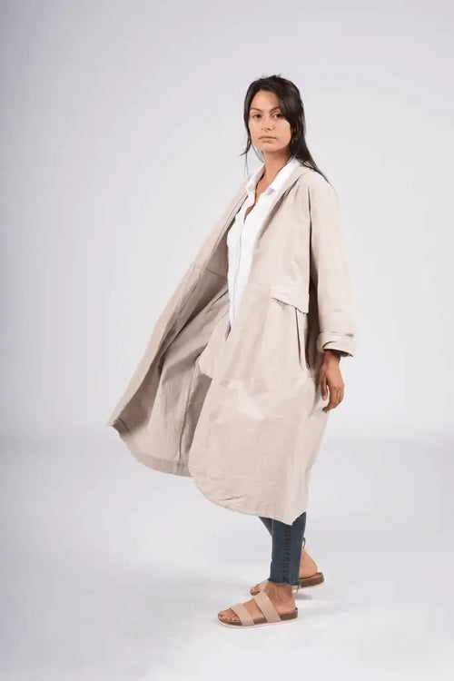 Woman wearing a frederic beige trench coat on a white background