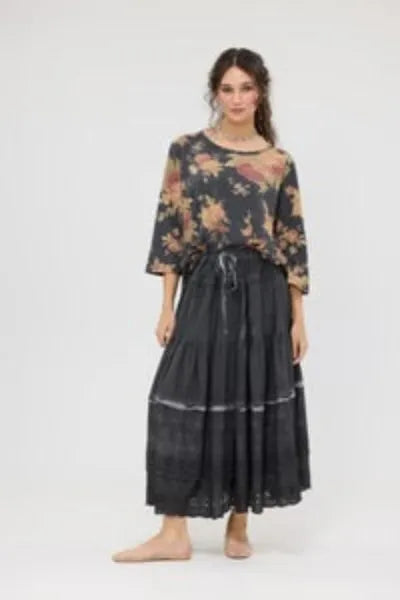 Woman wearing a floral top and black skirt on a white background